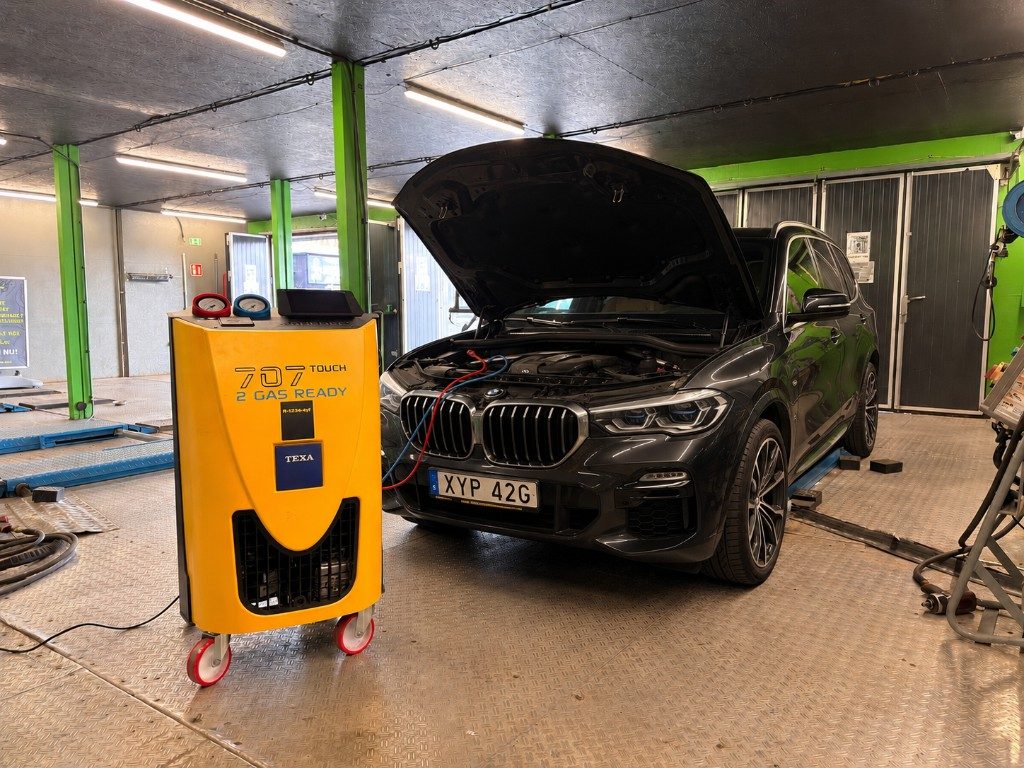 AC-service på bil i verkstad med professionell kylmedelsmaskin